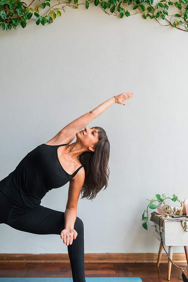 Stress Management and Spine Health. Image shows: Close up of a latina woman in side angle pose. Regular movement: Gentle stretching or low-impact exercise to release tension Mindfulness practices: Yoga, meditation, or deep breathing exercises.