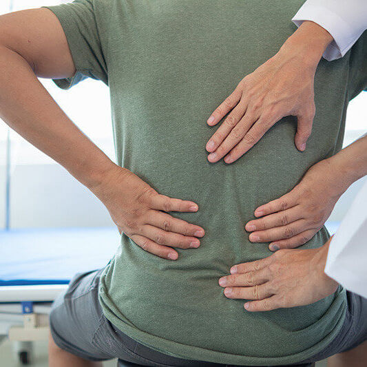 Clinician applying PEMF therapy to a patient’s lower back for spinal health